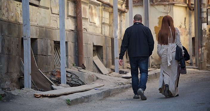 Мужчина и женщина идут по старому Тбилиси