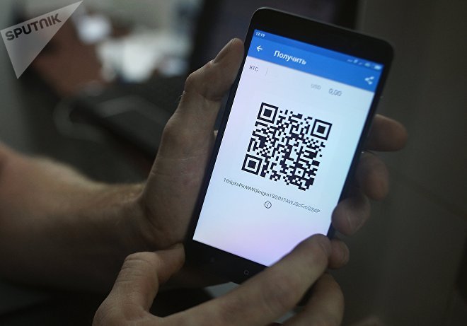 Демонстрация на смартфоне мобильного приложения для работы с криптовалютой биткоин в стационарном обменном пункте криптовалют в Москве Демонстрация на смартфоне мобильного приложения для работы с криптовалютой биткоин в стационарном обменном пункте криптовалют в Москве